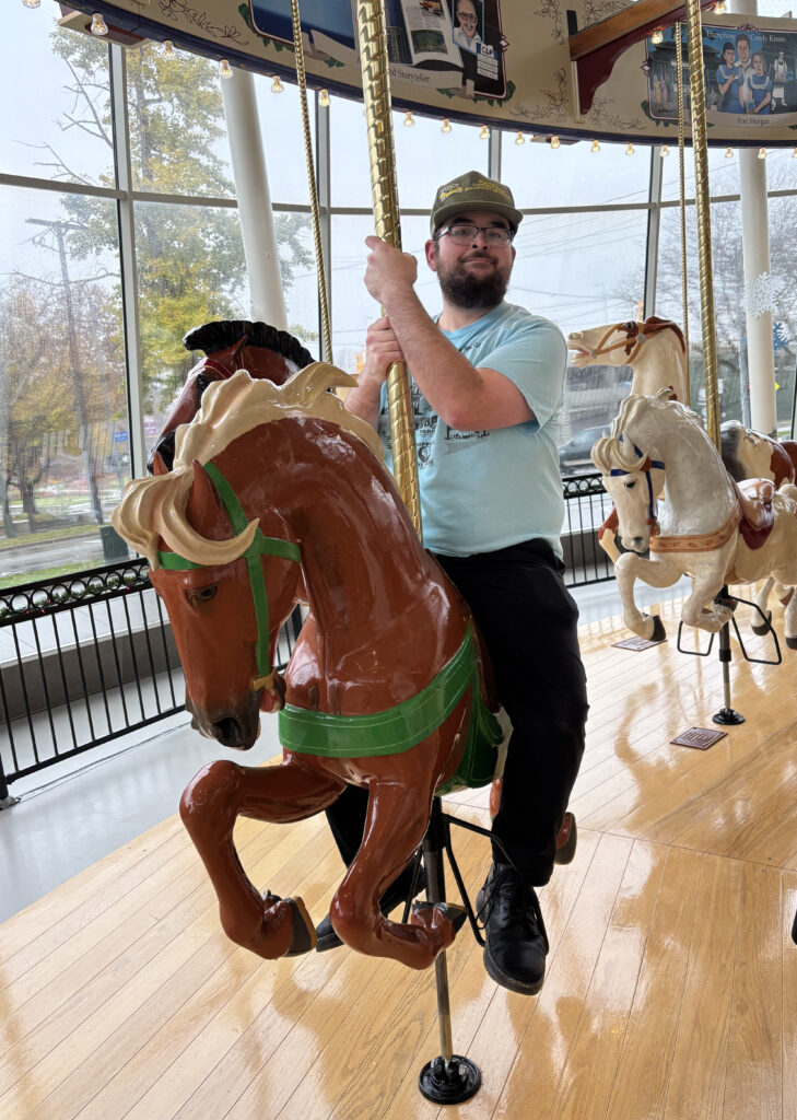 Kevin at the Cleveland History Center in 2024, riding the restored Euclid Beach Park Grand Carousel